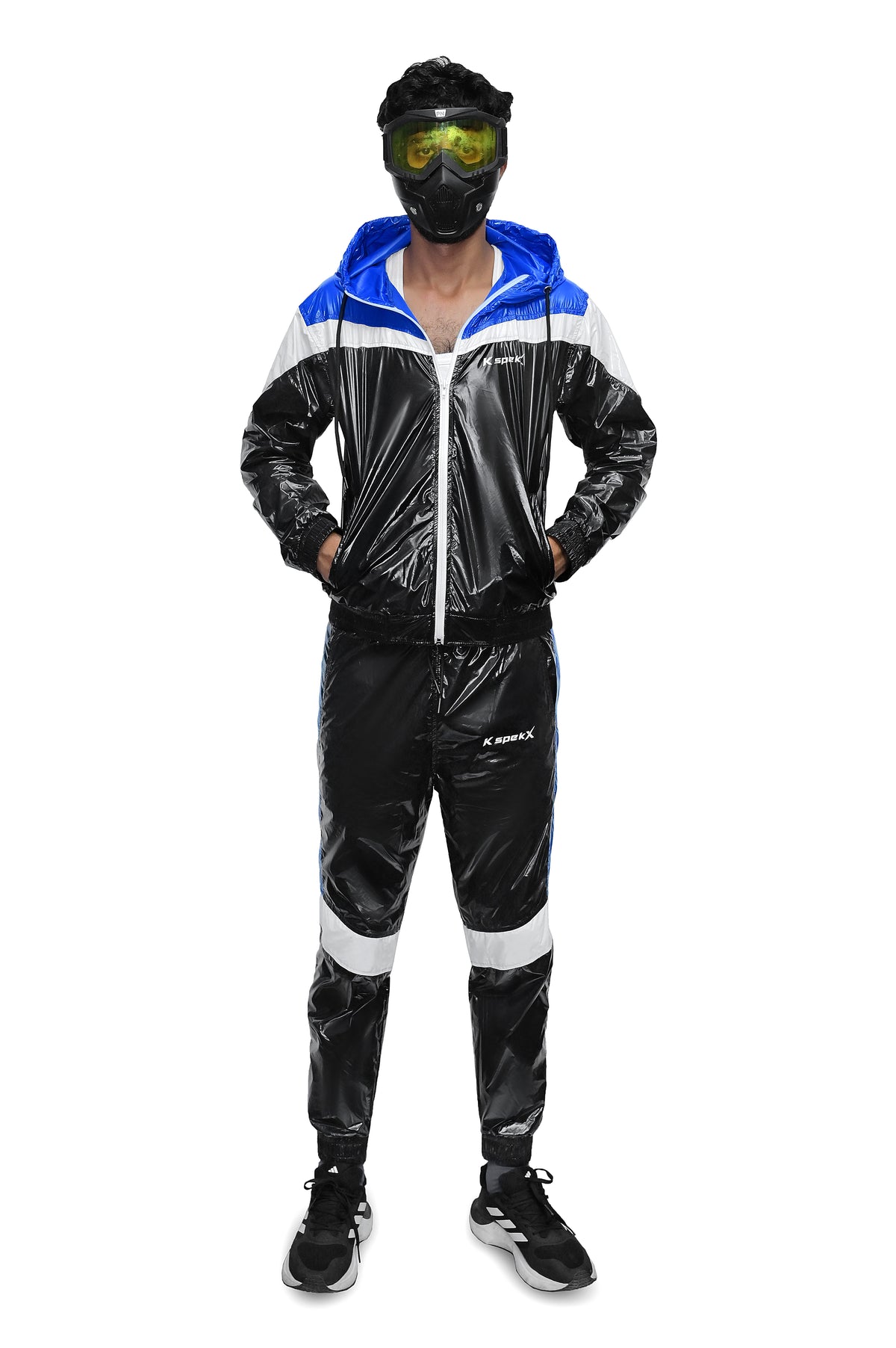A person modeling a shiny black, white, and blue hooded tracksuit with a glossy vinyl-like finish, standing against a plain white background. The tracksuit has a blue hood lining, white shoulder panels, and white side stripes on the pants.
